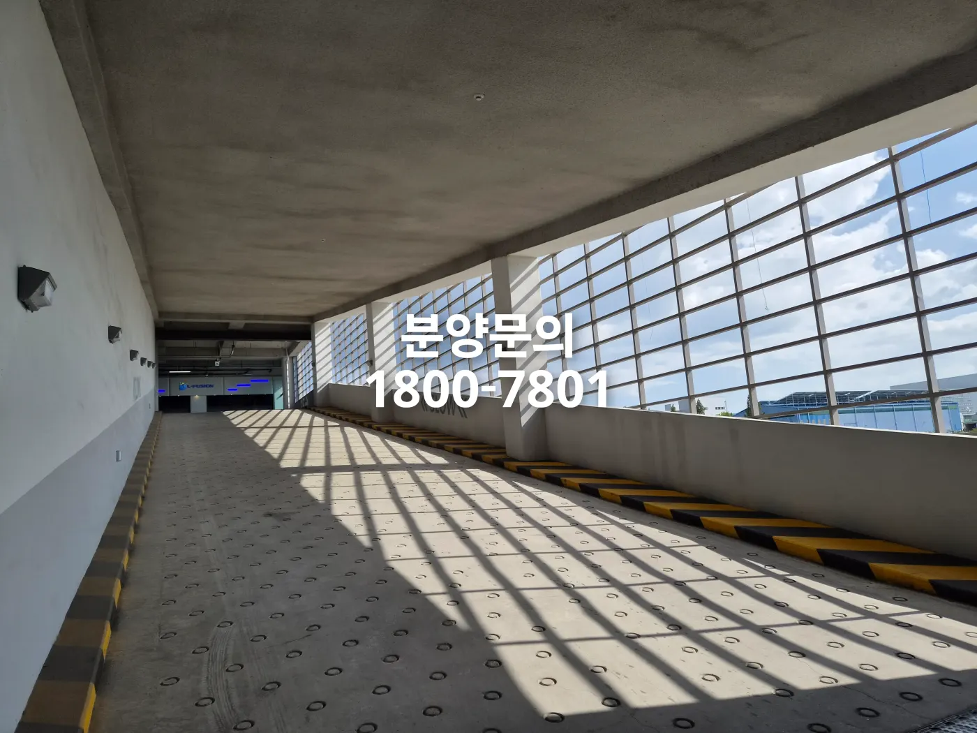 대전 플랫폼시티 차량 진입 램프. 미끄럼 방지 원형 홈이 있는 콘크리트 경사로와 격자 창으로 들어오는 자연광이 보이는 현장 사진